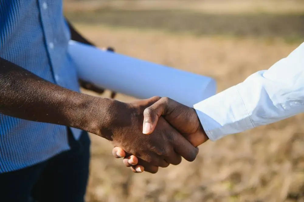 two male surveyors shaking hands
